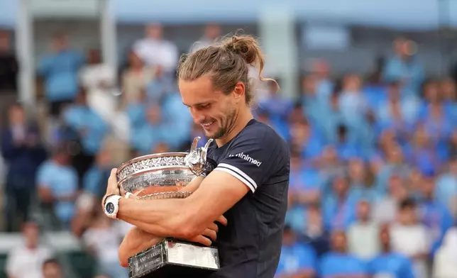Alexander Zverev of Germany hugs the trophy after winning the men's final match against Flavio Cobolli of Italy at the French Open tennis tournament in Paris, Sunday, June 7, 2026. (AP Photo/Christophe Ena)