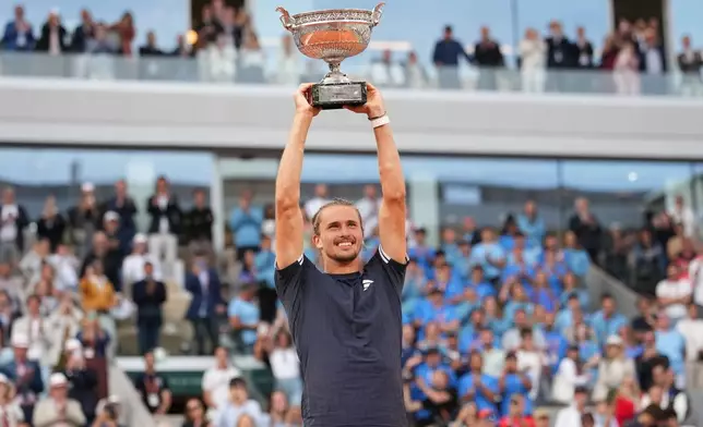 Alexander Zverev of Germany lifts the trophy after winning the men's final match against Flavio Cobolli of Italy at the French Open tennis tournament in Paris, Sunday, June 7, 2026. (AP Photo/Christophe Ena)