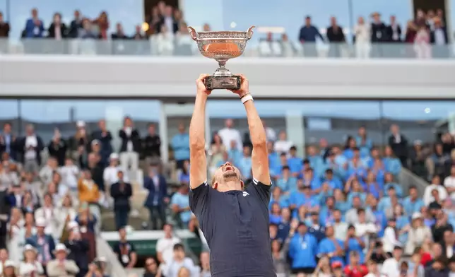 Alexander Zverev of Germany lifts the trophy after winning the men's final match against Flavio Cobolli of Italy at the French Open tennis tournament in Paris, Sunday, June 7, 2026. (AP Photo/Christophe Ena)
