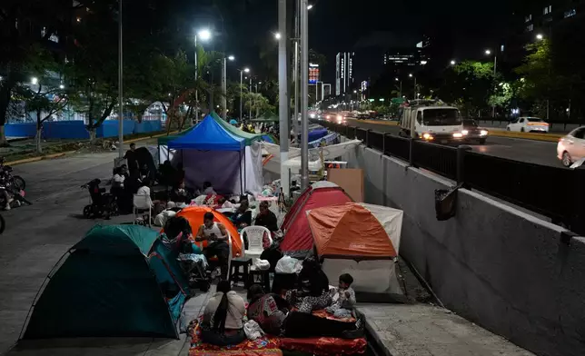 People camp in the street the night after the earthquake struck Caracas, Venezuela, Thursday, June 25, 2026. (AP Photo/Ariana Cubillos)