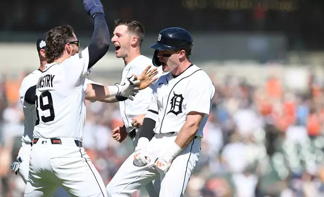 Detroit Tigers' Kevin McGonigle, right, celebrates with his teammates Zach McKinstry, left, and Zack Short, center, after hitting a two-run walk-off single against the Seattle Mariners in the ninth inning of a baseball game, Sunday, June 7, 2026, in Detroit. (AP Photo/Lon Horwedel)