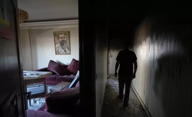 Resident Samih Haidar inspects his burned apartment damaged in Israeli strikes in the southern port city of Tyre, Lebanon, Thursday, June 18, 2026. (AP Photo/Hassan Ammar)