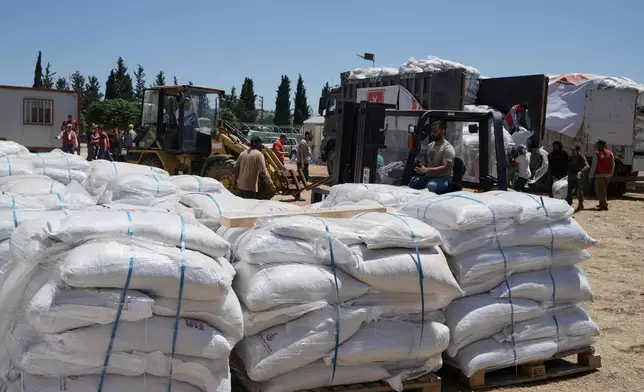 Workers unload emergency livestock feed and supplies for farmers from an aid convoy organized by the Order of Malta, a Catholic lay religious order, in the southern Christian village of Ain Ebel, Lebanon, Thursday, June 18, 2026. (AP Photo/Bilal Hussein)