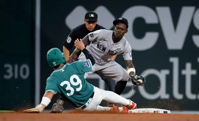 New York Yankees second baseman Jazz Chisholm Jr., right, gets an out against a steal-attempt by Boston Red Sox Tsung-Che Cheng (39) during the sixth inning of a baseball game, Friday, June 26, 2026, in Boston. (AP Photo/Mary Schwalm)