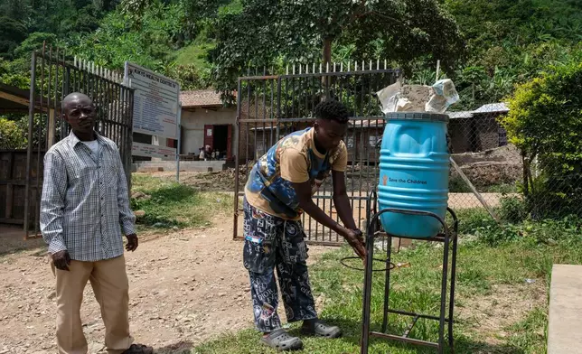 People wash their hands before entering Kikyo Health Centre IV in Kikyo Trading village, Bundibugyo District, Wednesday, June 3, 2026. (AP Photo/Hajarah Nalwadda)
