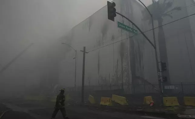 Smoke from a warehouse fire fills the air in the Boyle Heights neighborhood of Los Angeles, Sunday, June 21, 2026. (AP Photo/Jae C. Hong)