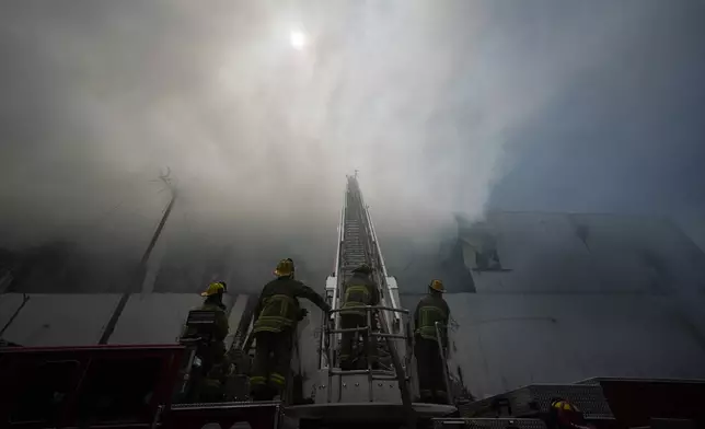 Firefighters fight a warehouse fire in the Boyle Heights neighborhood of Los Angeles, Sunday, June 21, 2026. (AP Photo/Jae C. Hong)