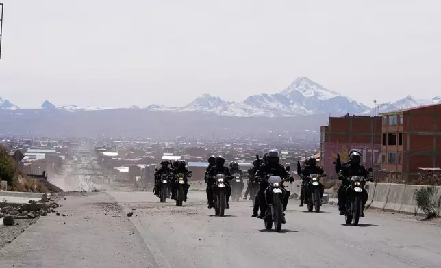 Police patrol a highway after President Rodrigo Paz declared a state of emergency to empower the military to remove road blockades, in El Alto, Bolivia, Saturday, June 20, 2026. (AP Photo/Juan Karita)