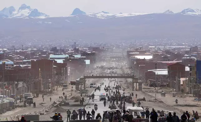 Residents walk on a highway after President Rodrigo Paz declared a state of emergency to empower the military to remove road blockades, in El Alto, Bolivia, Saturday, June 20, 2026. (AP Photo/Juan Karita)