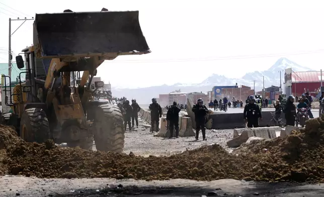 Police clear a highway blocked by protesters after President Rodrigo Paz declared a state of emergency in El Alto, Bolivia, Saturday, June 20, 2026. (AP Photo/Juan Karita)