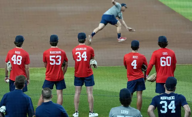 Rintaro Sasaki, of Japan, a first baseman at Stanford, fields a grounder as other players wait their turn at the MLB baseball combine in Phoenix, Tuesday, June 23, 2026. (AP Photo/Ross D. Franklin)