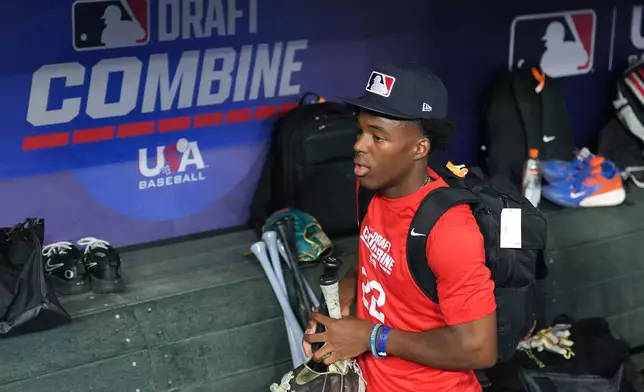 James Clark, a shortstop from St. John Bosco High School, gathers his gear in the dugout at the MLB baseball combine in Phoenix, Tuesday, June 23, 2026. (AP Photo/Ross D. Franklin)
