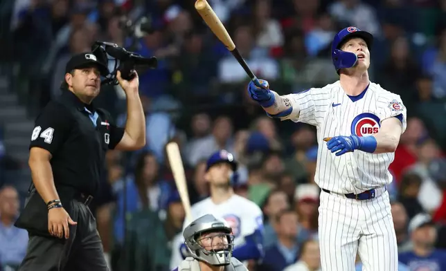 Chicago Cubs' Pete Crow-Armstrong, right, watches his home run as the umpire, back left, and Colorado Rockies catcher Hunter Goodman, back center, watch during the fourth inning of a baseball game in Chicago, Wednesday, June 17, 2026. (AP Photo/Jessie Alcheh)