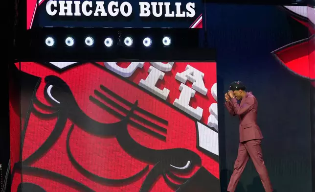 Dailyn Swain walks off the stage after being selected by the Chicago Bulls as the 15th pick in the first round of the NBA basketball draft, Tuesday, June 23, 2026, in New York. (AP Photo/Yuki Iwamura)