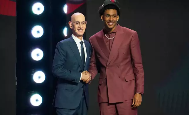 Dailyn Swain, right, poses for a photo with NBA Commissioner Adam Silver, left, after being selected by the Chicago Bulls as the 15th pick in the first round of the NBA basketball draft, Tuesday, June 23, 2026, in New York. (AP Photo/Yuki Iwamura)