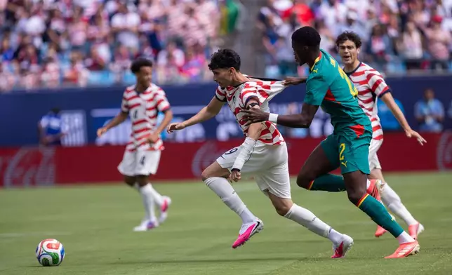 United States forward Ricardo Pepi, front left, is grabbed by Senegal defender Mamadou Sarr (2) during the first half of an international friendly soccer match Sunday, May 31, 2026, in Charlotte, N.C. (AP Photo/Scott Kinser)