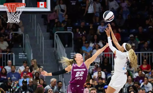 Atlanta Dream's Jordin Canada, right, shoots over Toronto Tempo's Julie Allemand (22) during the first half of a WNBA basketball game in Toronto, Sunday, June 14, 2026. (Sammy Kogan/The Canadian Press via AP)