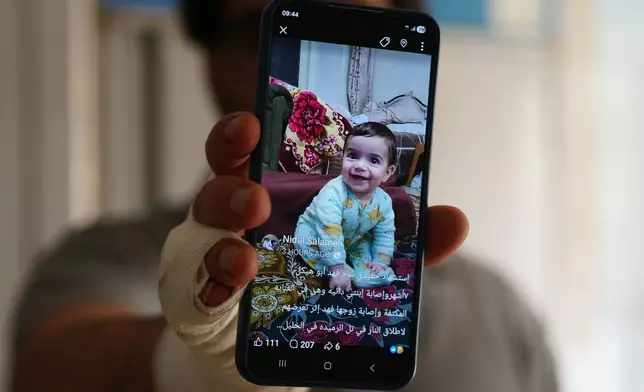 Fahd Abu Heikal, 41 displays a mobile photo of his seven month old Palestinian baby boy Sam, who was killed on Friday when Israeli soldiers fired at the vehicle carrying him and his parents in Tel Rumeida, at a hospital in the West Bank city of Hebron Saturday, June 6, 2026. (AP Photo/Mahmoud Illean)
