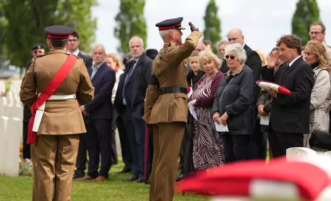 Folded flags are presented to relatives during a burial ceremony for six British soldiers of World War I, at the CWGC's Tyne Cot Cemetery in Zonnebeke, Belgium, Wednesday, June 10, 2026. (AP Photo/Virginia Mayo)