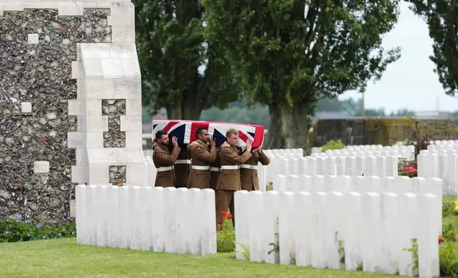 Soldiers from the Princess of Wales's Royal Regiment carry a coffin during a burial ceremony for six British soldiers of World War I, at the CWGC's Tyne Cot Cemetery in Zonnebeke, Belgium, Wednesday, June 10, 2026. (AP Photo/Virginia Mayo)