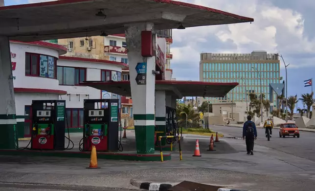 FILE - A man walks past a gas station that has run out of fuel, located near the U.S Embassy, pictured in the background, in Havana, Cuba, Feb. 7, 2026. (AP Photo/Ramon Espinosa, File)