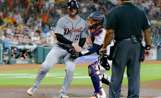 Detroit Tigers' Dillon Dingler is out at the plate on the tag by Houston Astros catcher Yainer Diaz, center, as umpire Adrian Johnson, right, looks on during the first inning of a baseball game, Tuesday, June 16, 2026, in Houston. (AP Photo/Michael Wyke)