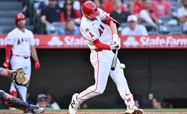 Los Angeles Angels' Trey Mancini hits an RBI single during the second inning of a baseball game against the Houston Astros, Monday, June 8, 2026, in Anaheim, Calif. (AP Photo/William Liang)