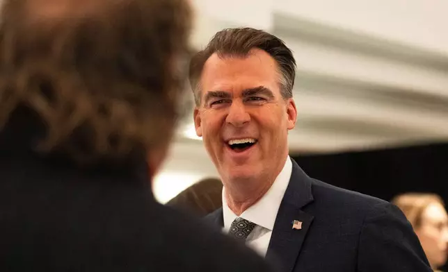 FILE - Oklahoma Gov. Kevin Stitt speaks with an individual following an event at the National Governors Association Winter Meeting, Feb. 19, 2026, in Washington. (AP Photo/Allison Robbert, File)