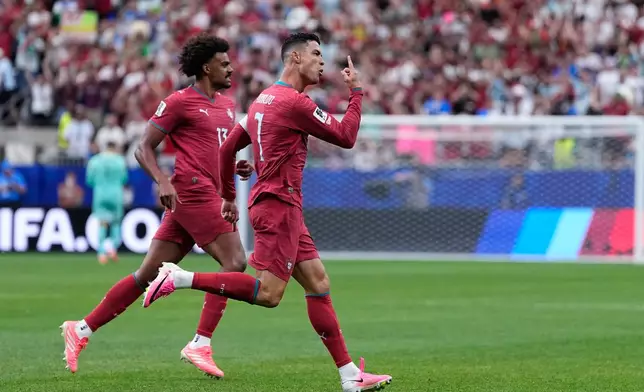 Portugal's Cristiano Ronaldo, right, celebrates after scoring the opening goal during the World Cup Group K soccer match between Portugal and Uzbekistan in Houston, Tuesday, June 23, 2026. (AP Photo/Ashley Landis)