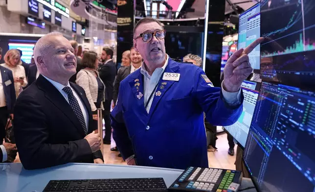 Anders Opedal, President and CEO of Norway's Equinor, left, meets with specialist Patrick King on the floor of the New York Stock Exchange, after he rang the closing bell, Tuesday, June 16, 2026. (AP Photo/Richard Drew)