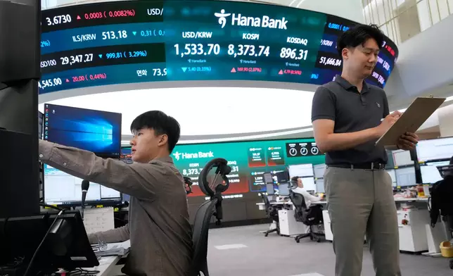 Currency traders work near a screen showing the Korea Composite Stock Price Index (KOSPI) and the foreign exchange rate between U.S. dollar and South Korean won at the foreign exchange dealing room of the Hana Bank headquarters in Seoul, South Korea, Wednesday, June 24, 2026. (AP Photo/Ahn Young-joon)