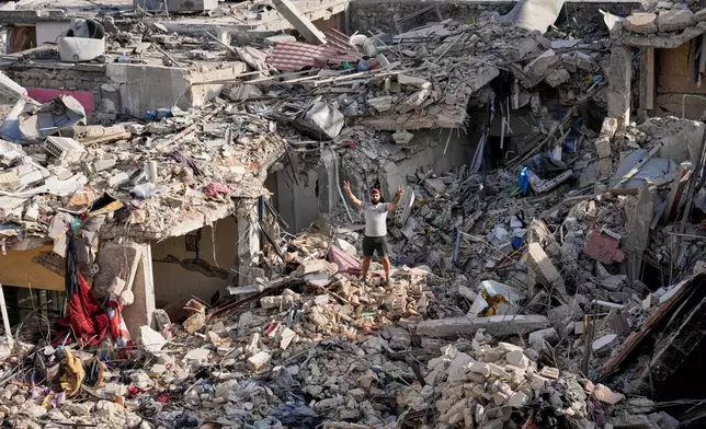 A man who returns to his village following the announcement of an initial ceasefire agreement between the United States and Iran, flashes victory sign as he stands on the rubble of his destroyed house in Nabatiyeh town, southern Lebanon, Tuesday, June 16, 2026. (AP Photo/Hussein Malla)
