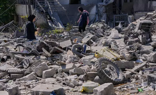 Sukaina al-Muhtadi, left, and her mother Aida who returned to their village following the announcement of an initial ceasefire agreement between the United States and Iran, search for their belongings between the rubble of their destroyed house in Nabatiyeh town, southern Lebanon, Tuesday, June 16, 2026. (AP Photo/Hussein Malla)