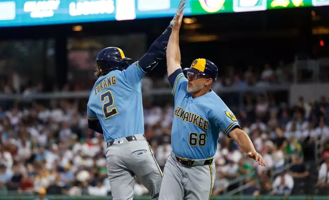Milwaukee Brewers' Brice Turang (2) is greeted by third base coach Matt Erickson, right, as he rounds the bases after hitting a two-run home run during the third inning of a baseball game against the Athletics, Monday, June 8, 2026, in Las Vegas. (AP Photo/Caroline Brehman)