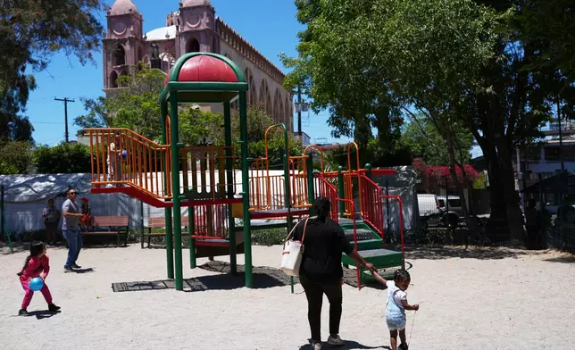 Vivianne Petit Frere walks with her granddaughter Alexca at a playground, June 22, 2026, in Tijuana, Mexico. (AP Photo/Gregory Bull)