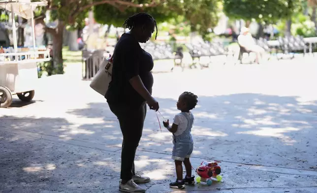 Vivianne Petit Frere talks with granddaughter Alexca at a park, June 22, 2026, in Tijuana, Mexico. (AP Photo/Gregory Bull)