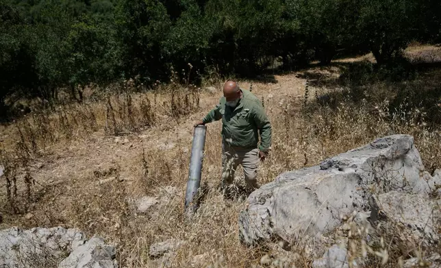Zaki Maron inspects part of a rocket that fell on his farm in the southern Christian village of Ain Ebel, Lebanon, Thursday, June 18, 2026. (AP Photo/Bilal Hussein)