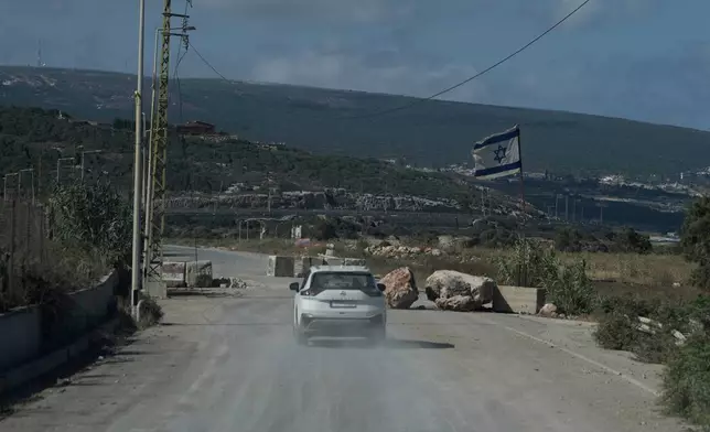 A car drives past an Israeli flag placed along a road in the southern town of Naqoura, Lebanon, Thursday, June 18, 2026. (AP Photo/Bilal Hussein)