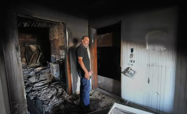 Resident Samih Haidar reacts as he inspects his burned apartment damaged in Israeli strikes in the southern port city of Tyre, Lebanon, Thursday, June 18, 2026. (AP Photo/Hassan Ammar)