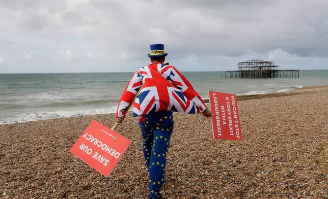 FILE- Anti Brexit campaigner Steve Bray walks on the beach to pose for a photograph during the Labour Party Conference at the Brighton Centre in Brighton, England, Monday, Sept. 23, 2019. (AP Photo/Kirsty Wigglesworth, File)