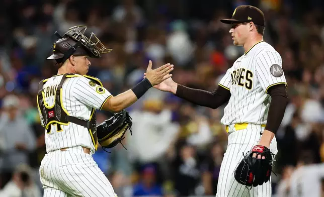 San Diego Padres' Mason Miller, right, celebrates with Freddy Fermin after the team defeated the New York Mets in a baseball game Saturday, June 6, 2026, in San Diego. (AP Photo/Derrick Tuskan)