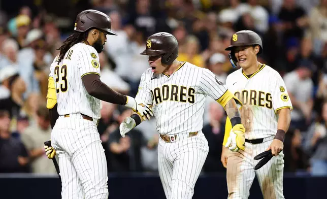 San Diego Padres' Freddy Fermin, center, celebrates with Fernando Tatis Jr. after hitting a two-run home run against the New York Mets in the seventh inning of a baseball game Saturday, June 6, 2026, in San Diego. (AP Photo/Derrick Tuskan)
