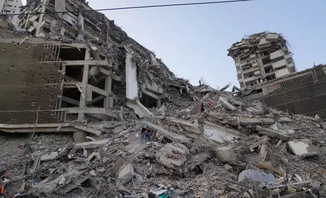 Residents search through the rubble two days after an earthquake struck La Guaira, Venezuela, Friday, June 26, 2026. (AP Photo/Ariana Cubillos)