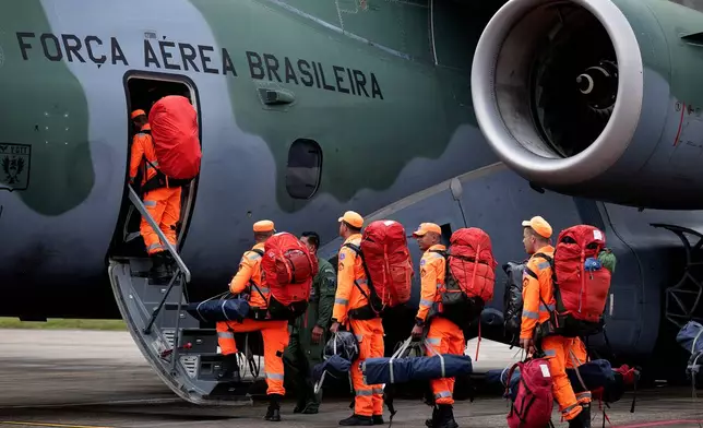 Brazilian military firefighters board a Brazilian Air Force aircraft before departing on a humanitarian mission to assist victims of the doublet in earthquakes in Venezuela at the Guarulhos Air Base in Sao Paulo, Brazil, Friday, June 26, 2026. (AP Photo/Ettore Chiereguini)