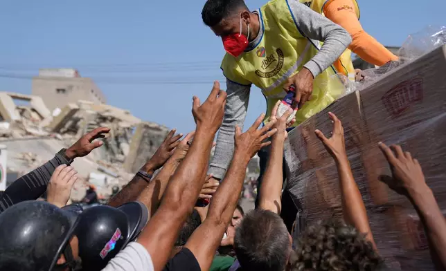 Members of a religious organization distribute food to people affected two days after an earthquake struck La Guaira, Venezuela, Friday, June 26, 2026. (AP Photo/Ariana Cubillos)