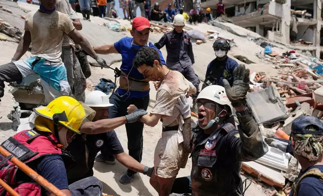 Rescue workers pull Daniel Cordero from the rubble of his home in Catia la Mar, Venezuela, Friday, June 26, 2026, two days after twin earthquakes struck the country. (AP Photo/Fernando Vergara)