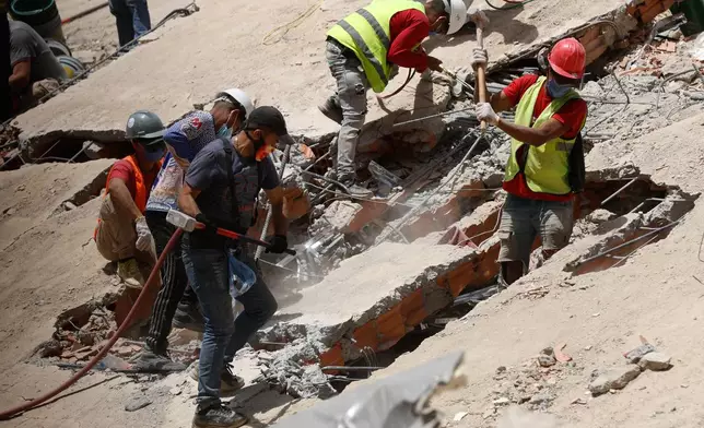 Rescue worker search through the rubble of a collapsed building two days after earthquakes struck Caracas, Venezuela, Friday, June 26, 2026. (AP Photo/Pedro Mattey)