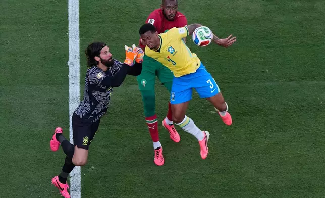 Brazil goalkeeper Alisson Becker, left, punches the ball out as teammate Gabriel Magalhaes (3) and Morocco's Issa Diop watch during the World Cup Group C soccer match in East Rutherford, N.J., near New York, Saturday, June 13, 2026. (AP Photo/Matt Slocum)