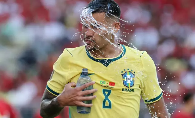 Brazil's Bruno Guimaraes (8) cools down with a splash of water in the first half during the World Cup Group C soccer match between Brazil and Morocco in East Rutherford, N.J., near New York, Saturday, June 13, 2026. (AP Photo/Adam Hunger)