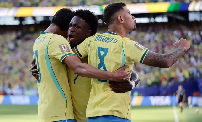 Brazil's Vinicius Junior (7) celebrates a goal with teammates Lucas Paqueta (20) and Bruno Guimaraes (8) in the first half during the World Cup Group C soccer match between Brazil and Morocco in East Rutherford, N.J., near New York, Saturday, June 13, 2026. (AP Photo/Adam Hunger)